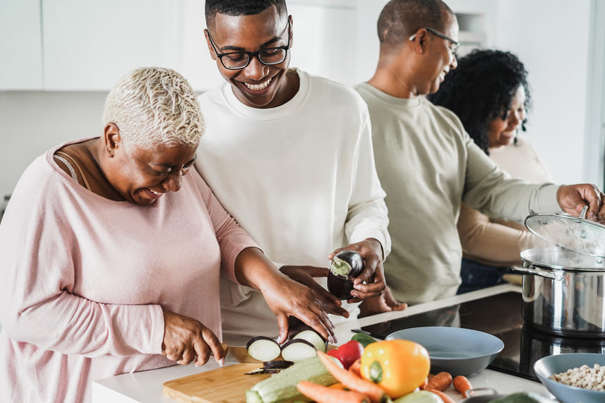 emagrecimento saudável: família negra cozinhando junta legumes e verduras